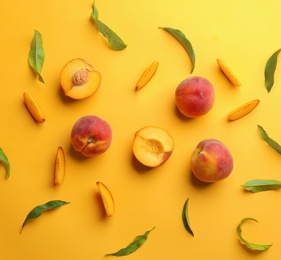 Flat lay composition with fresh peaches on yellow background