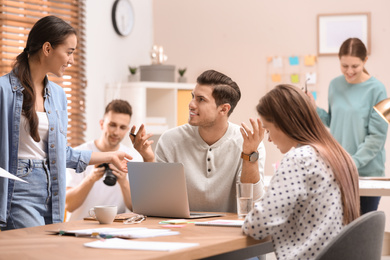 Photo of Team of professional journalists working in office