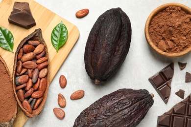 Photo of Flat lay composition with cocoa pods and chocolate on light table