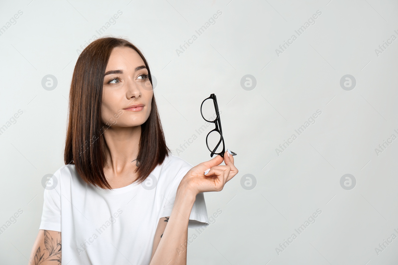 Photo of Portrait of pretty young woman with gorgeous chestnut hair on light background, space for text