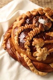 Photo of Korovai on tablecloth, closeup. Ukrainian bread and salt welcoming tradition