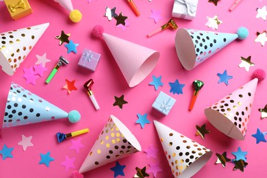 Flat lay composition with party hats on pink background