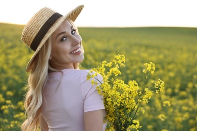 Portrait of happy young woman in field on spring day