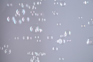 Beautiful transparent soap bubbles on grey background