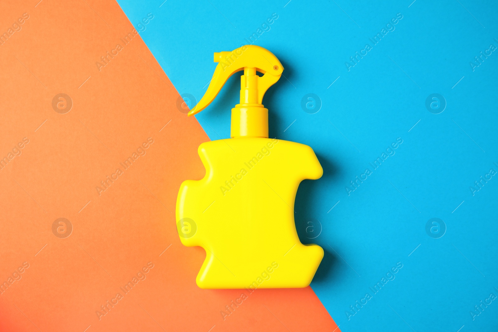 Photo of Bottle with sun protection body cream on color background, top view