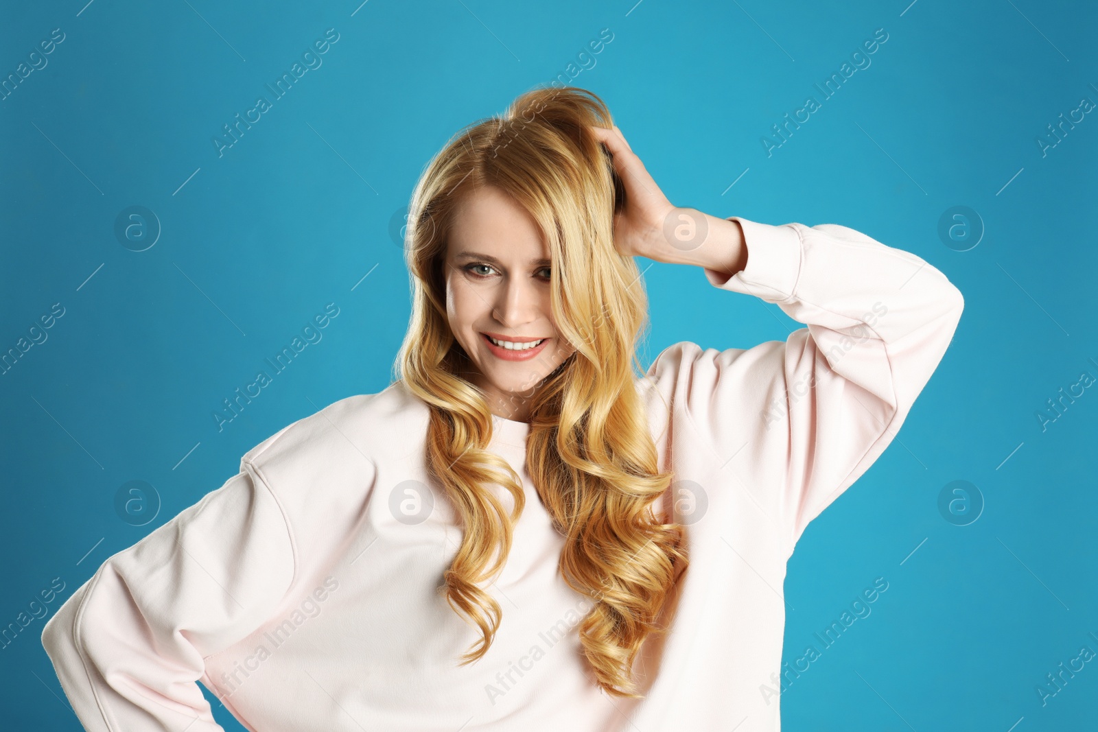 Photo of Portrait of beautiful young woman with dyed long hair on blue background