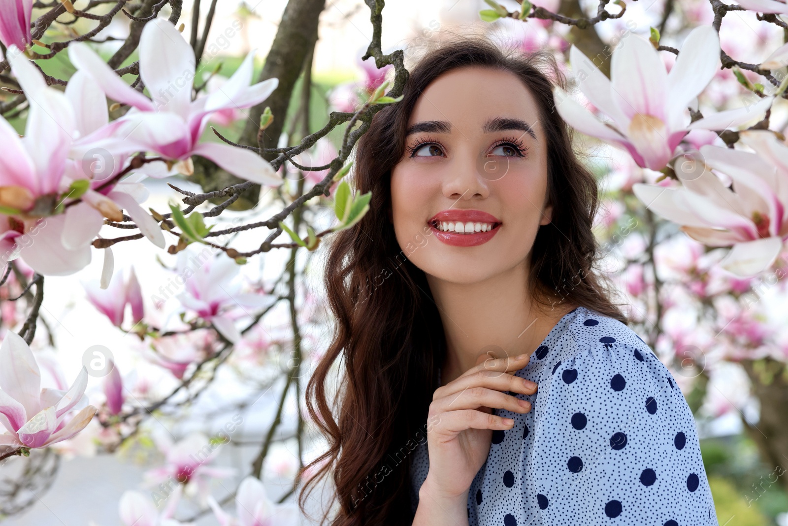 Photo of Beautiful woman near blossoming magnolia tree on spring day