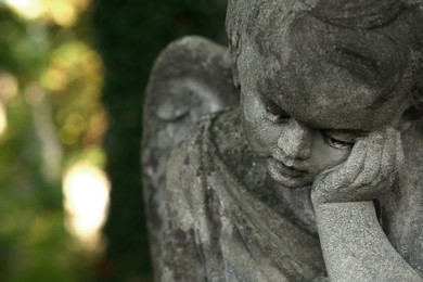 Photo of Beautiful statue of angel outdoors, closeup with space for text. Funeral ceremony