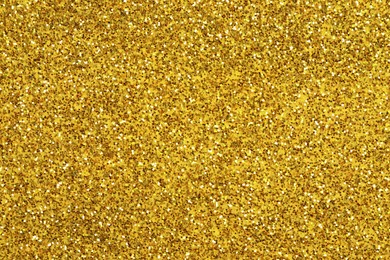 Photo of Beautiful golden shiny glitter as background, top view