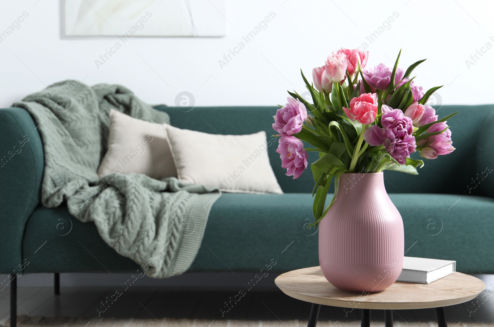 Photo of Beautiful bouquet of colorful tulip flowers on coffee table in room, space for text