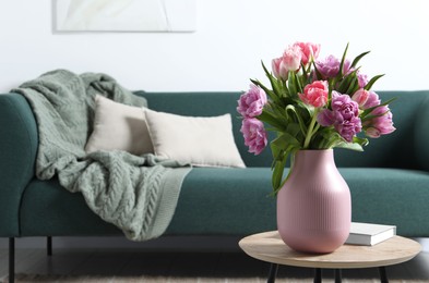 Photo of Beautiful bouquet of colorful tulip flowers on coffee table in room, space for text