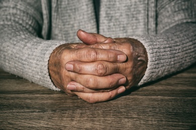 Photo of Poor senior woman at table, closeup of hands