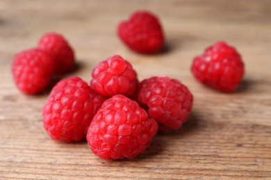 Heap of tasty ripe raspberries on wooden table, closeup