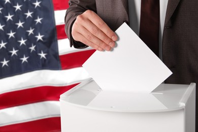 Image of Man putting his vote into ballot box against national flag of United States, closeup. Space for text