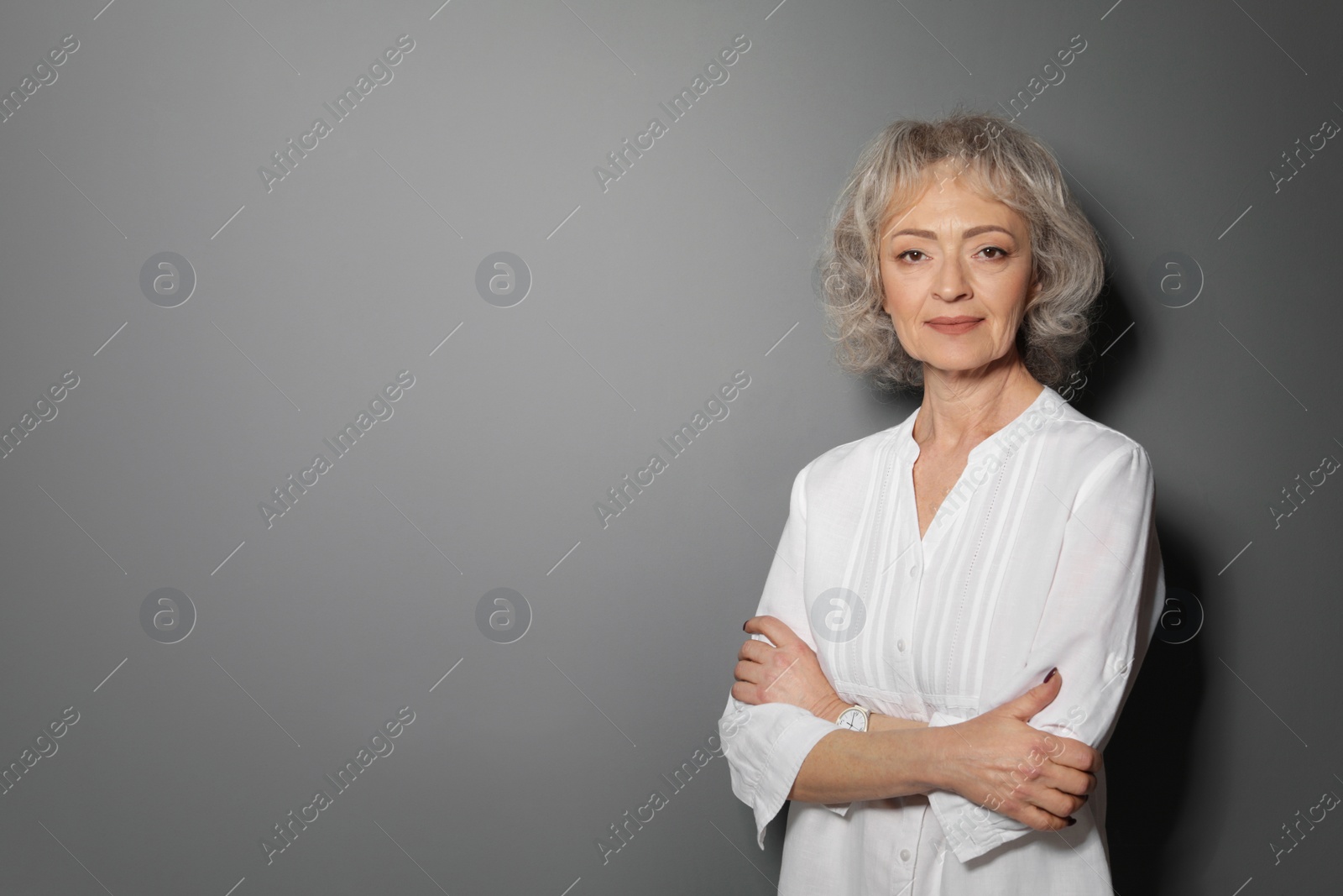 Photo of Portrait of mature woman on grey background. Space for text