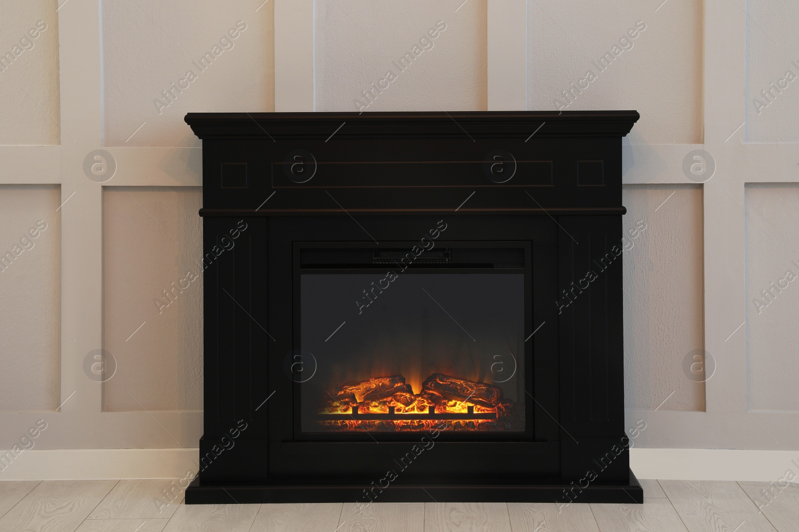 Photo of Modern electric fireplace near light wall indoors