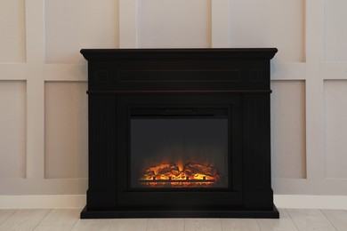 Photo of Modern electric fireplace near light wall indoors