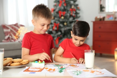 Photo of Little children drawing picture at home. Christmas celebration