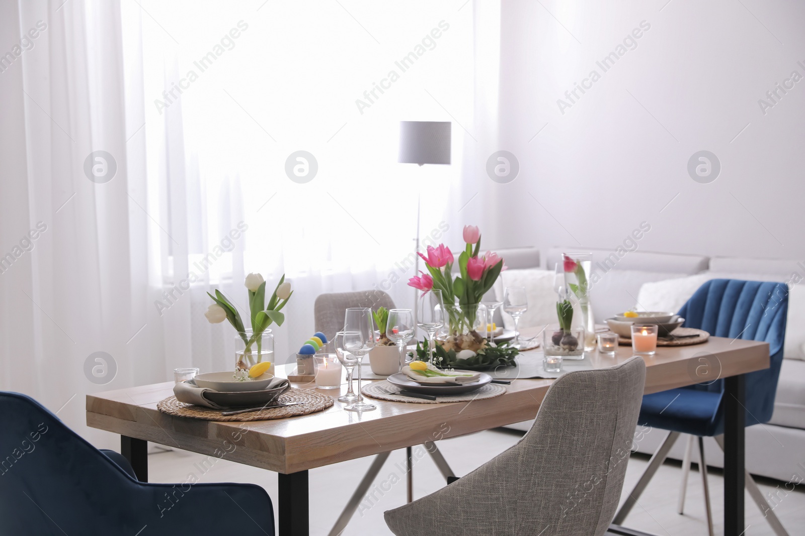 Photo of Beautiful Easter table setting with beautiful flowers in living room