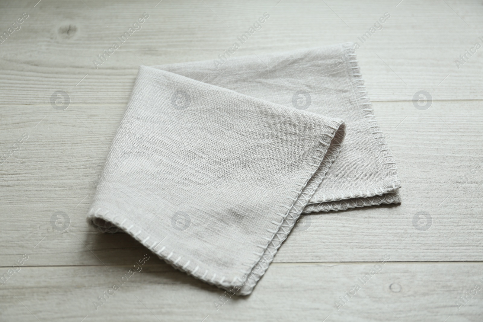 Photo of Light folded napkin on white wooden table