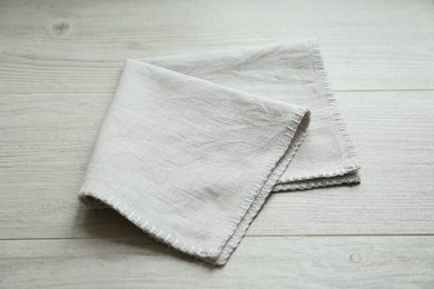 Light folded napkin on white wooden table