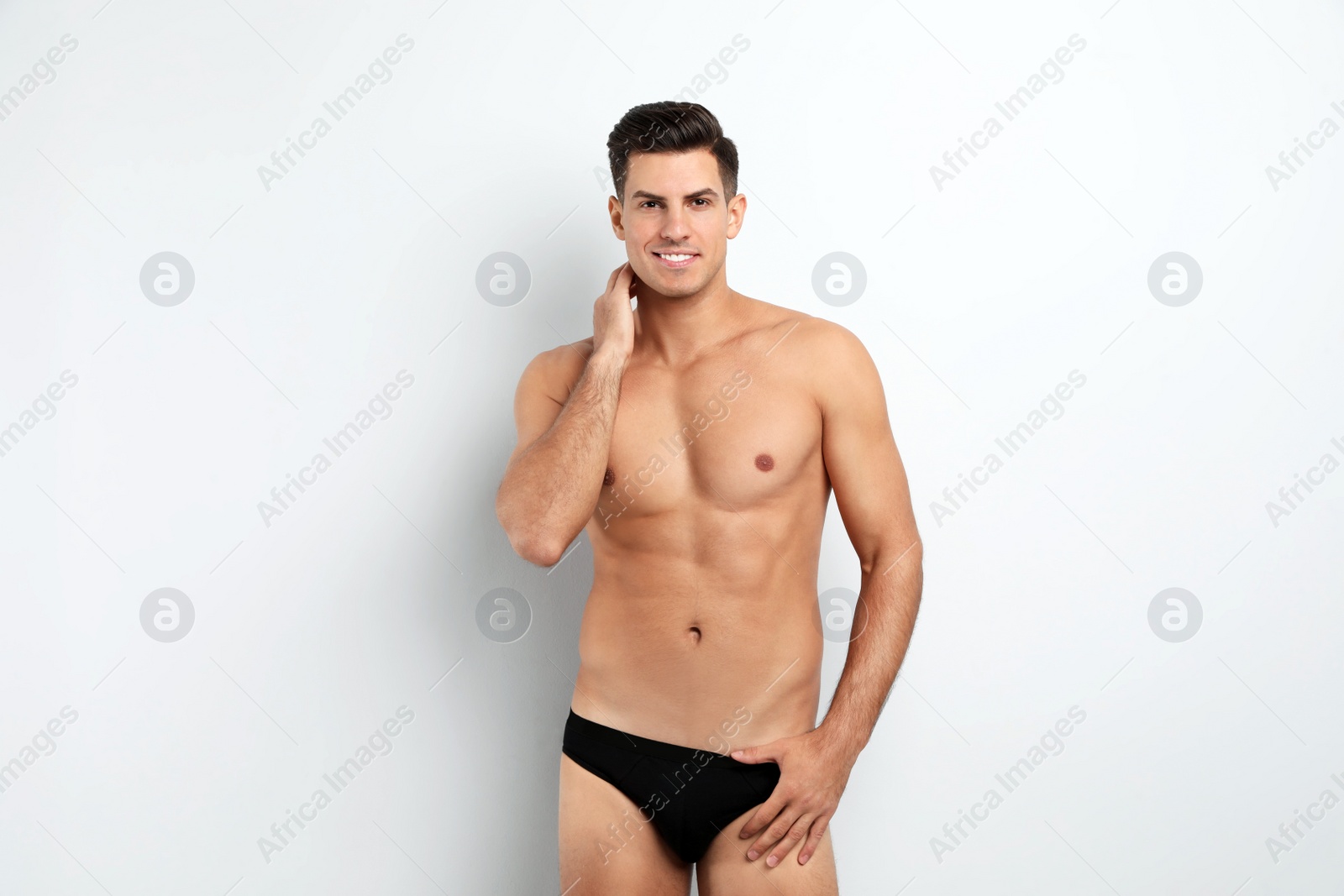 Photo of Handsome man in black underwear on white background