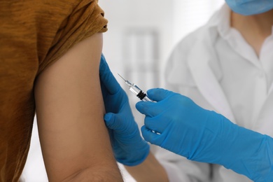 Photo of Doctor giving injection to patient in hospital, closeup. Vaccination campaign