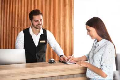 Receptionist registering client at desk in lobby