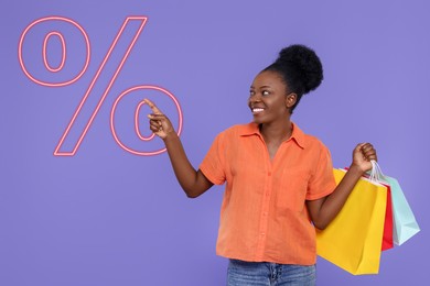 Image of Discount offer. Happy woman with paper shopping bags pointing at illustration of percent sign on purple background