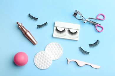 Photo of Flat lay composition with magnetic eyelashes and accessories on light blue background