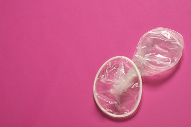 Photo of Unrolled female condom on pink background, space for text. Safe sex