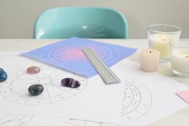 Photo of Zodiac wheels and gemstones for making forecast of fate on table. Astrological predictions