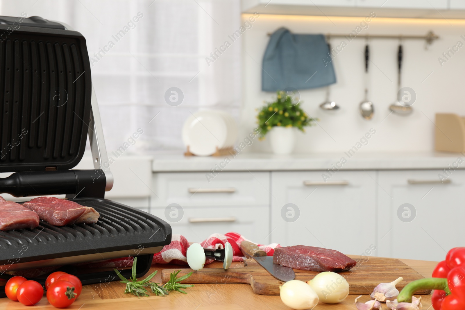 Photo of Electric grill and different products on wooden table