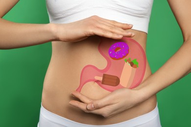 Woman with image of stomach full of junk food drawn on her belly against green background, closeup. Unhealthy eating habits