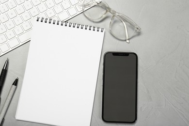 Flat lay composition with open notebook and smartphone on light grey table