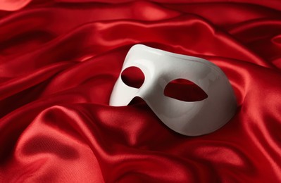 Photo of White plastic theatre mask on red fabric