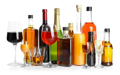 Photo of Bottles and glasses with different alcoholic drinks isolated on white