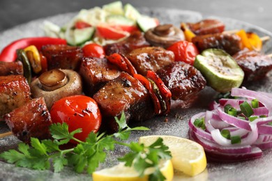 Photo of Delicious shish kebabs with vegetables on table, closeup