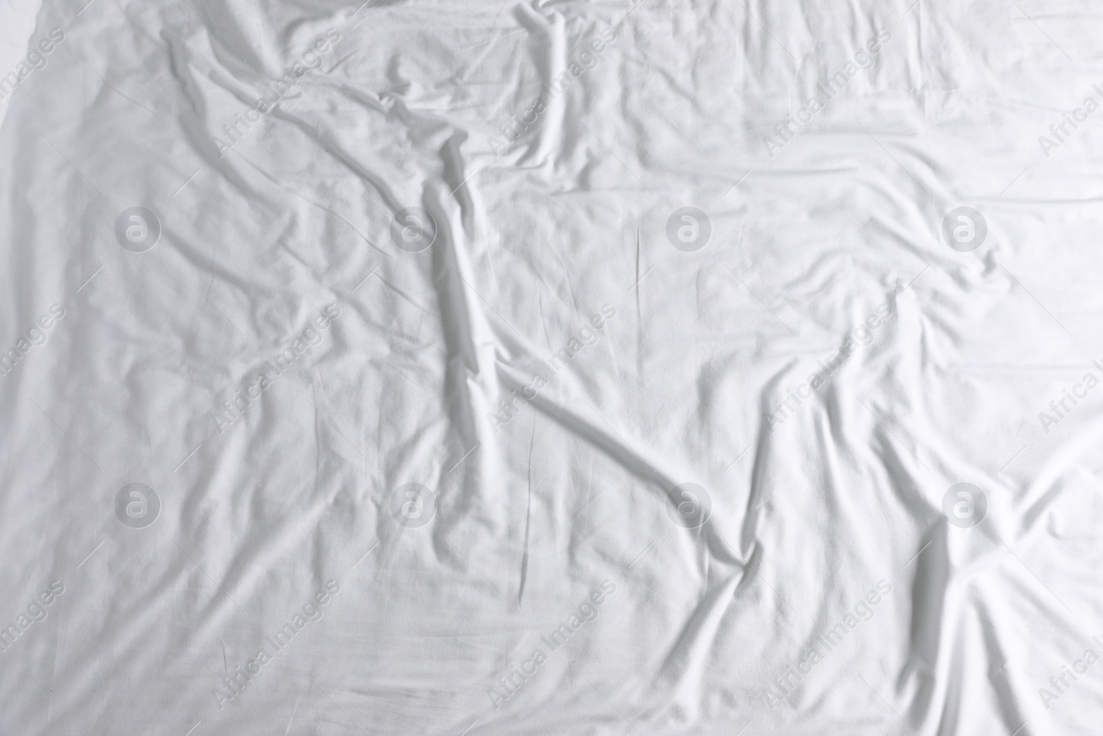 Photo of Crumpled white fabric as background, top view