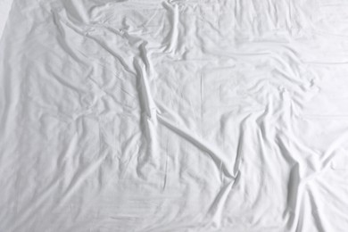 Photo of Crumpled white fabric as background, top view