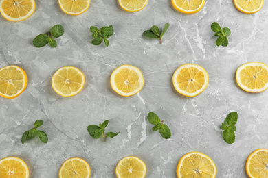 Photo of Lemonade layout with juicy lemon slices and mint on grey marble table, top view