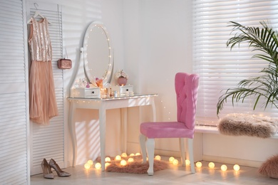 Photo of Elegant dressing table with lights and pink chair in stylish room interior