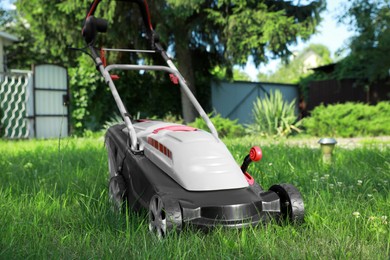 Lawn mower on green grass in garden