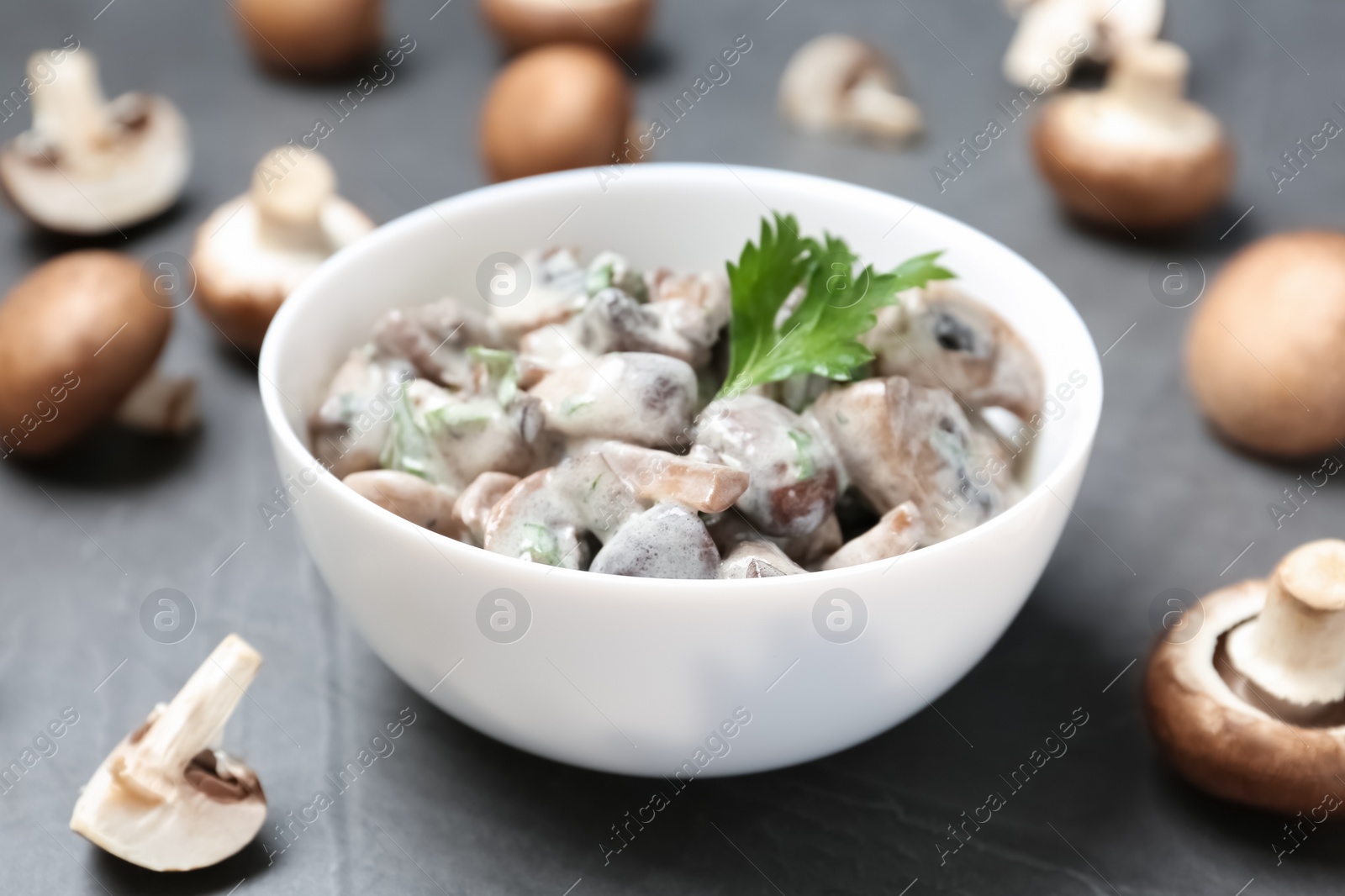 Photo of Bowl of fried mushrooms with sauce on table, closeup