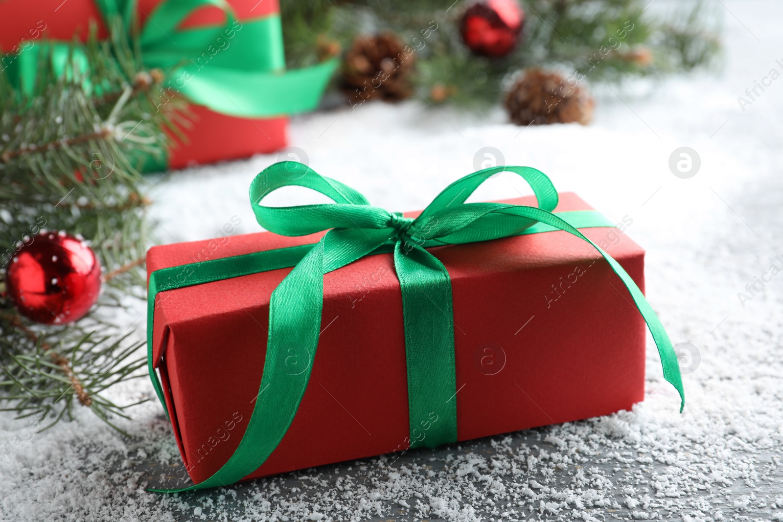 Photo of Gift boxes and Christmas decorations on table with artificial snow