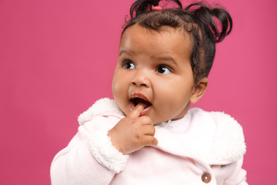 Photo of Cute African American baby on pink background