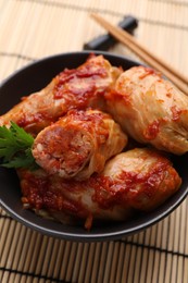 Photo of Delicious stuffed cabbage rolls cooked with homemade tomato sauce on table, closeup