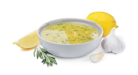 Bowl with lemon sauce and ingredients on white background. Delicious salad dressing