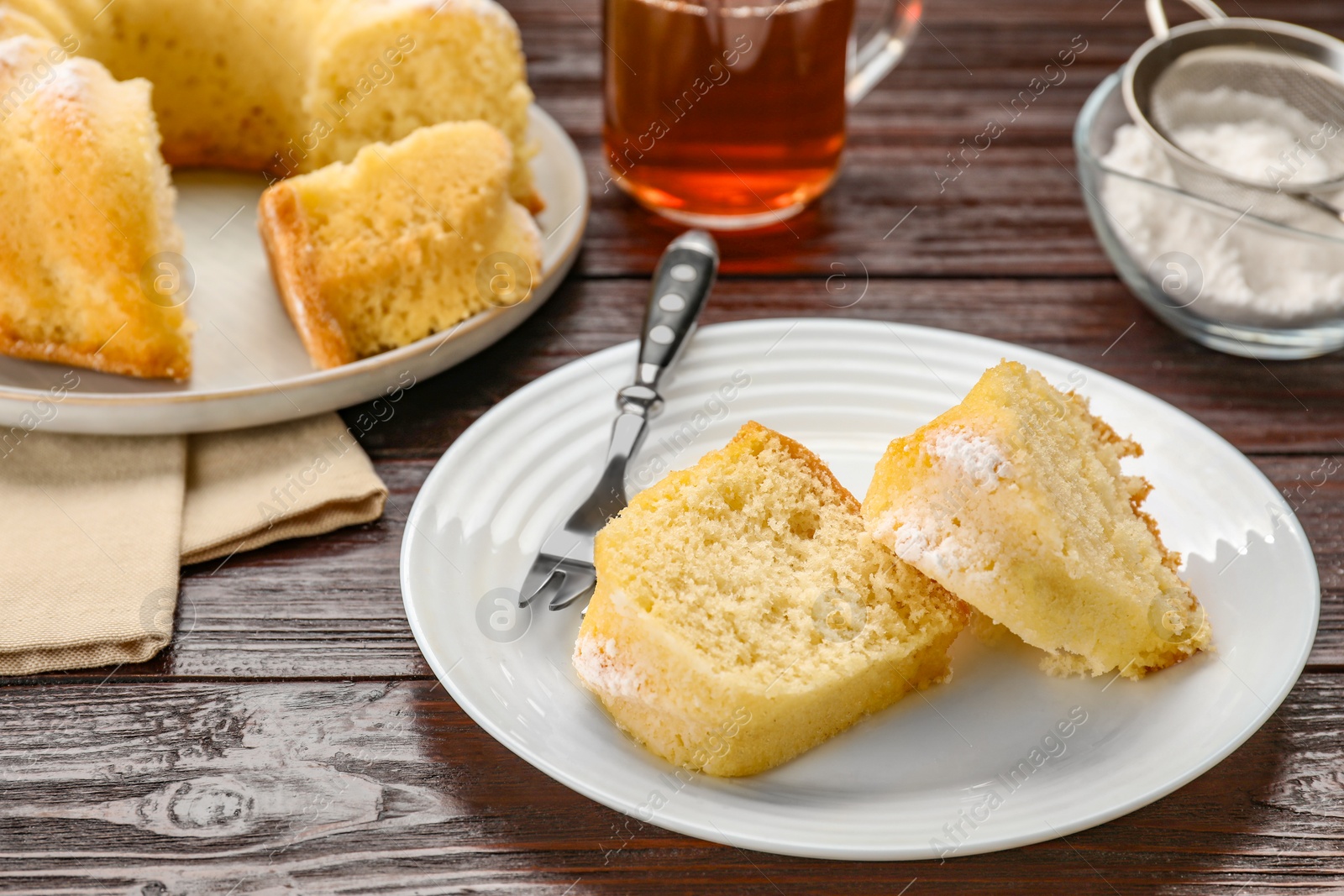 Photo of Delicious sponge cake served on wooden table, closeup