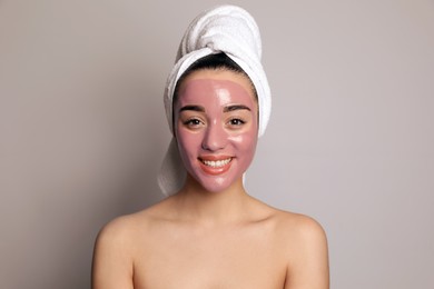 Photo of Woman with pomegranate face mask on grey background